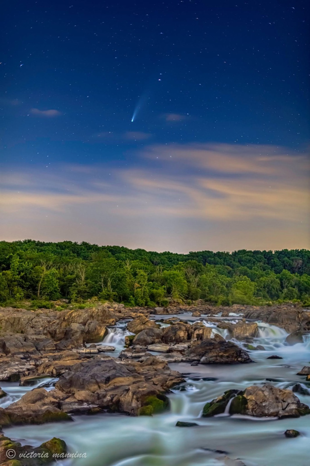 Vertical view of comet NEOWISE over cascading falls and forest